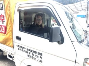 鹿児島市で不用品回収に向かう株式会社HAKKO（八光）の女性スタッフと許可番号記載のトラック