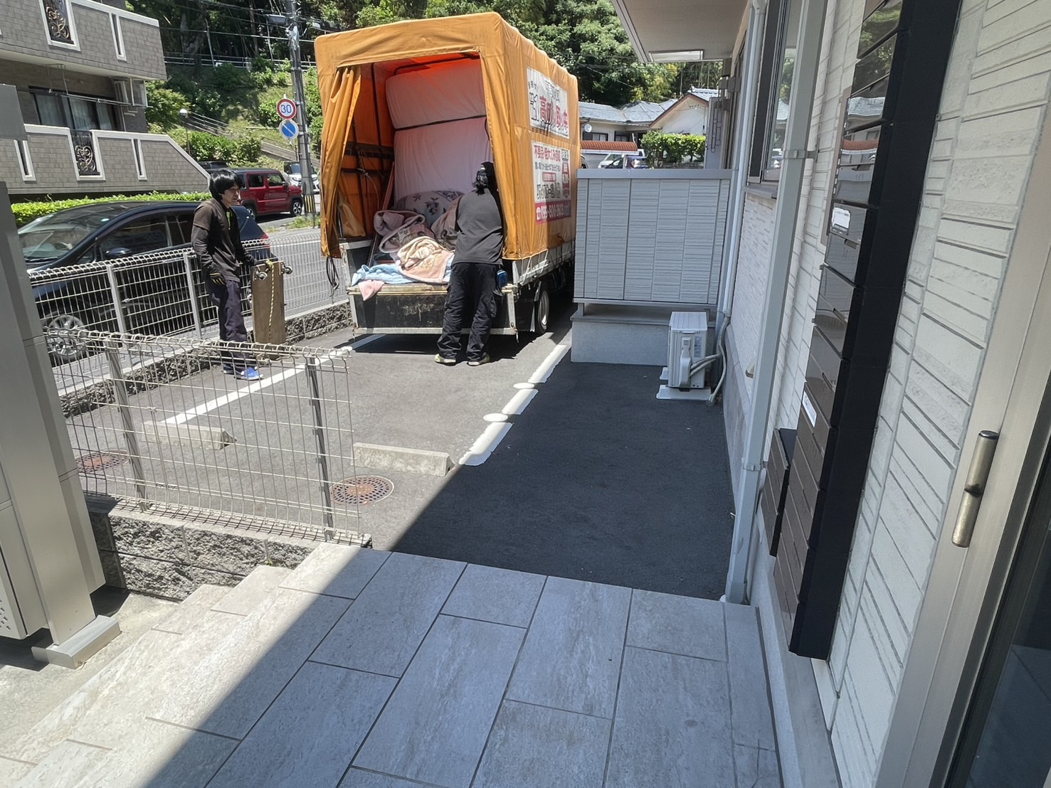 鹿児島市吉野のお客様邸前・HAKKOトラックへ23品の不用品を積み込み中(スタッフ2名)