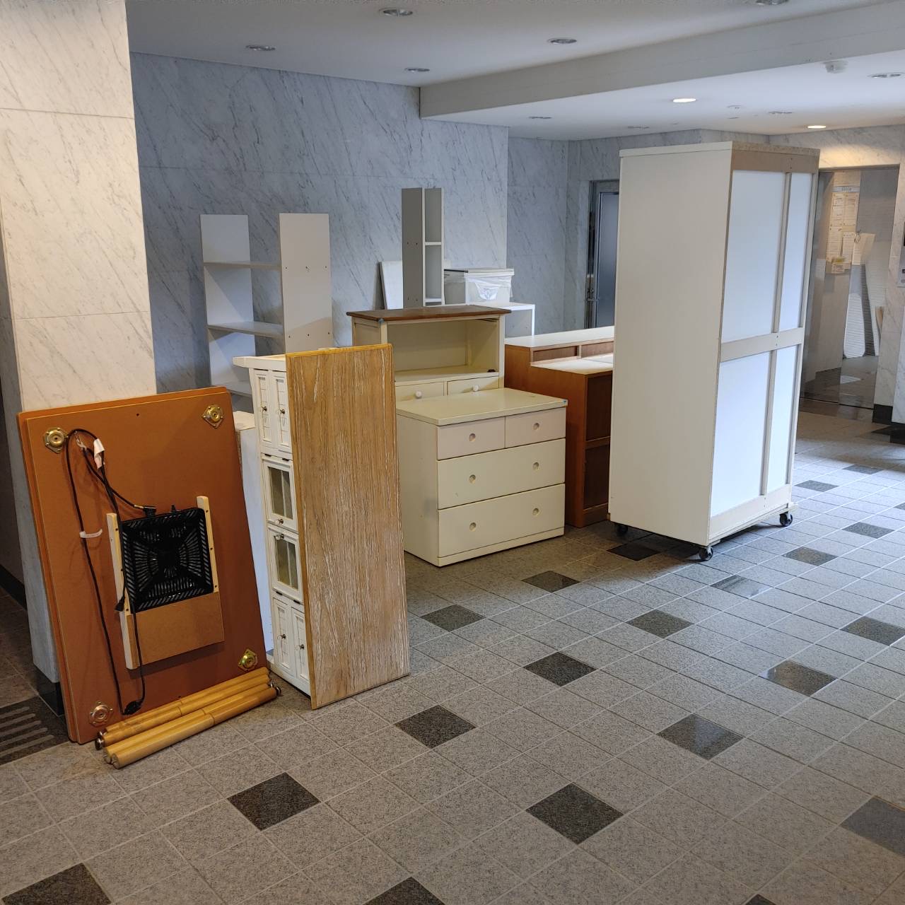 共用部に並んだ家具一式（食器棚・チェスト・ワードローブ・テーブル天板等）
