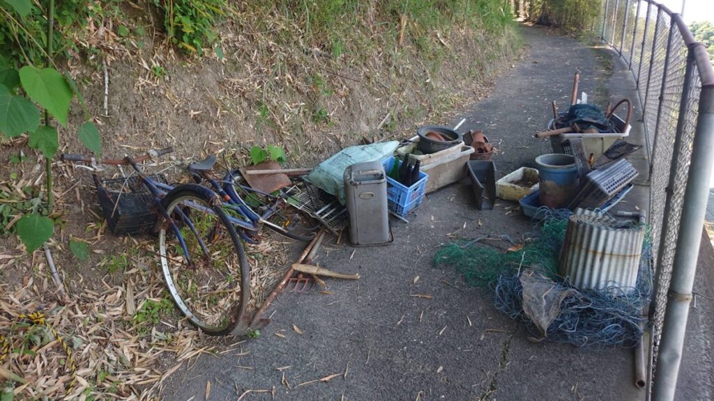 鹿児島市下伊敷の屋外に長年堆積した不用品（自転車・植木鉢・農具・廃材）の不用品回収現場
