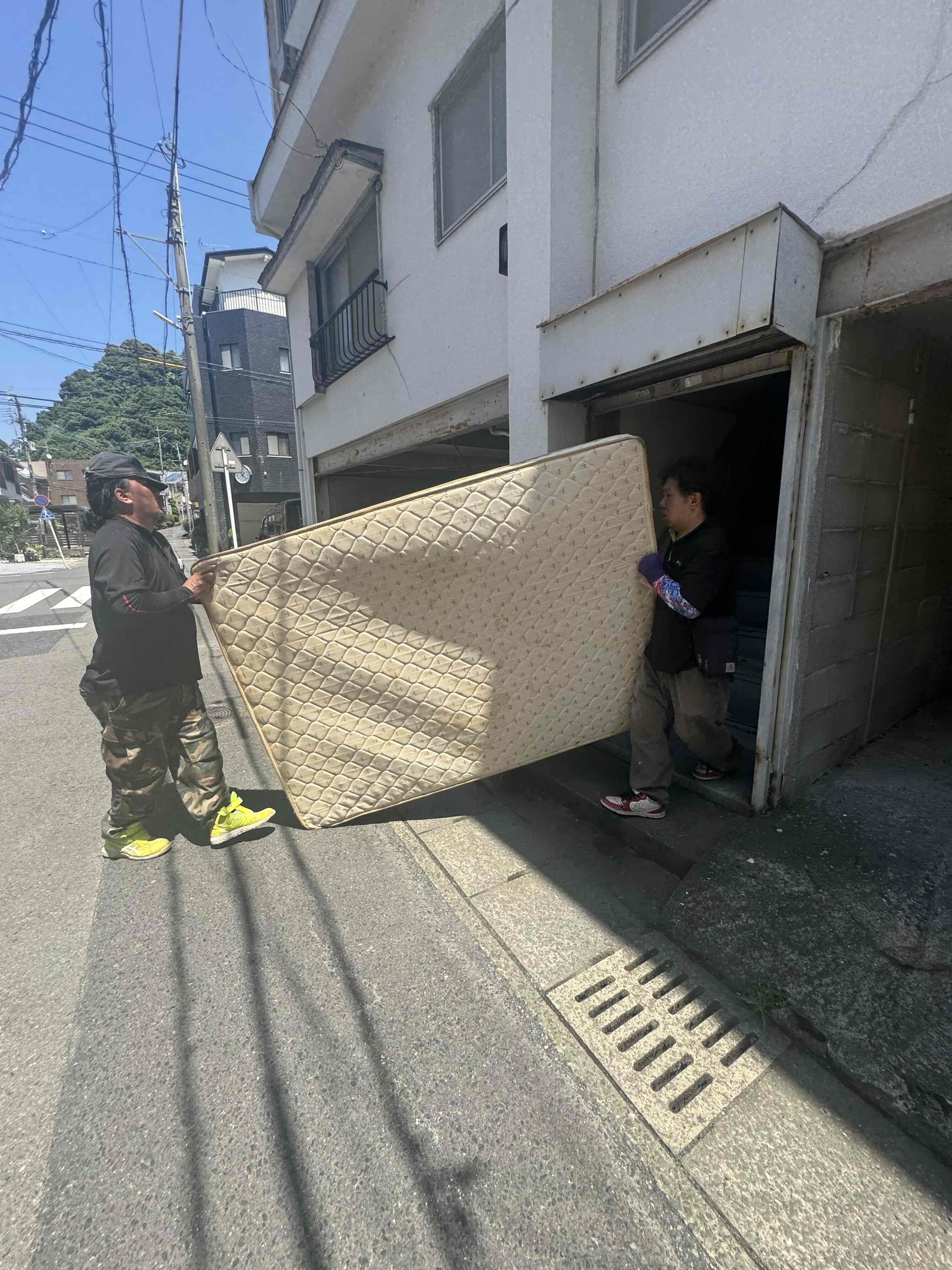 生前整理でマットレスを運び出す鹿児島市の作業風景
