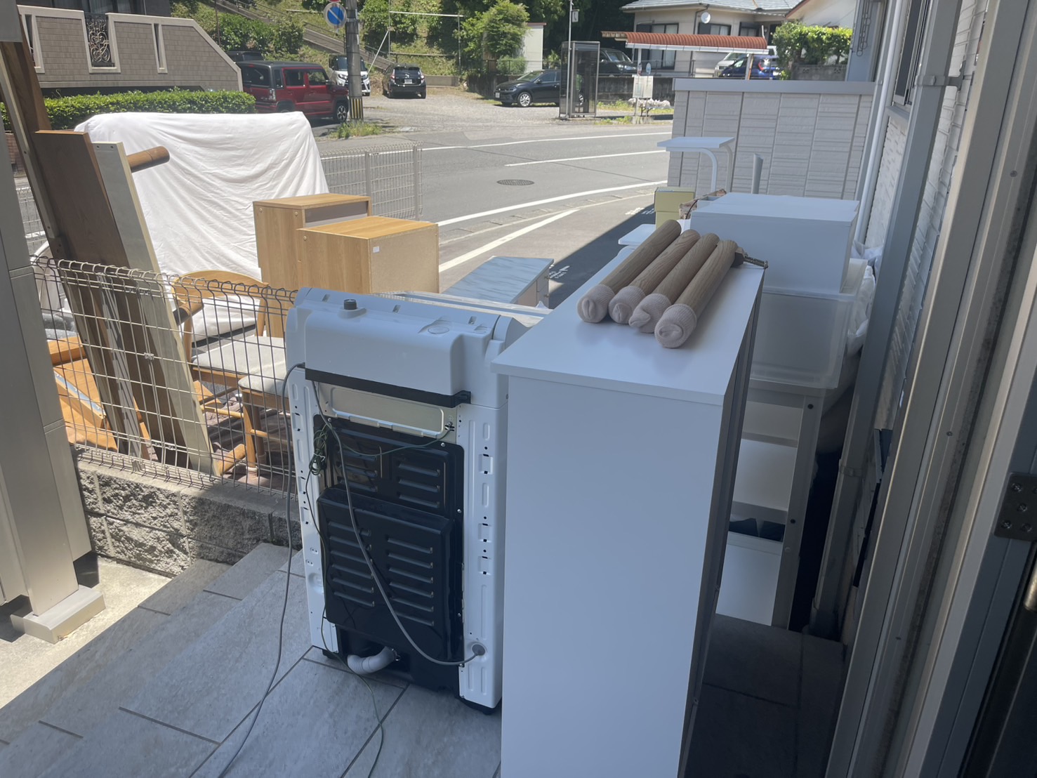 屋外に集積された処分品の一部(洗濯機・棚・布団マット)