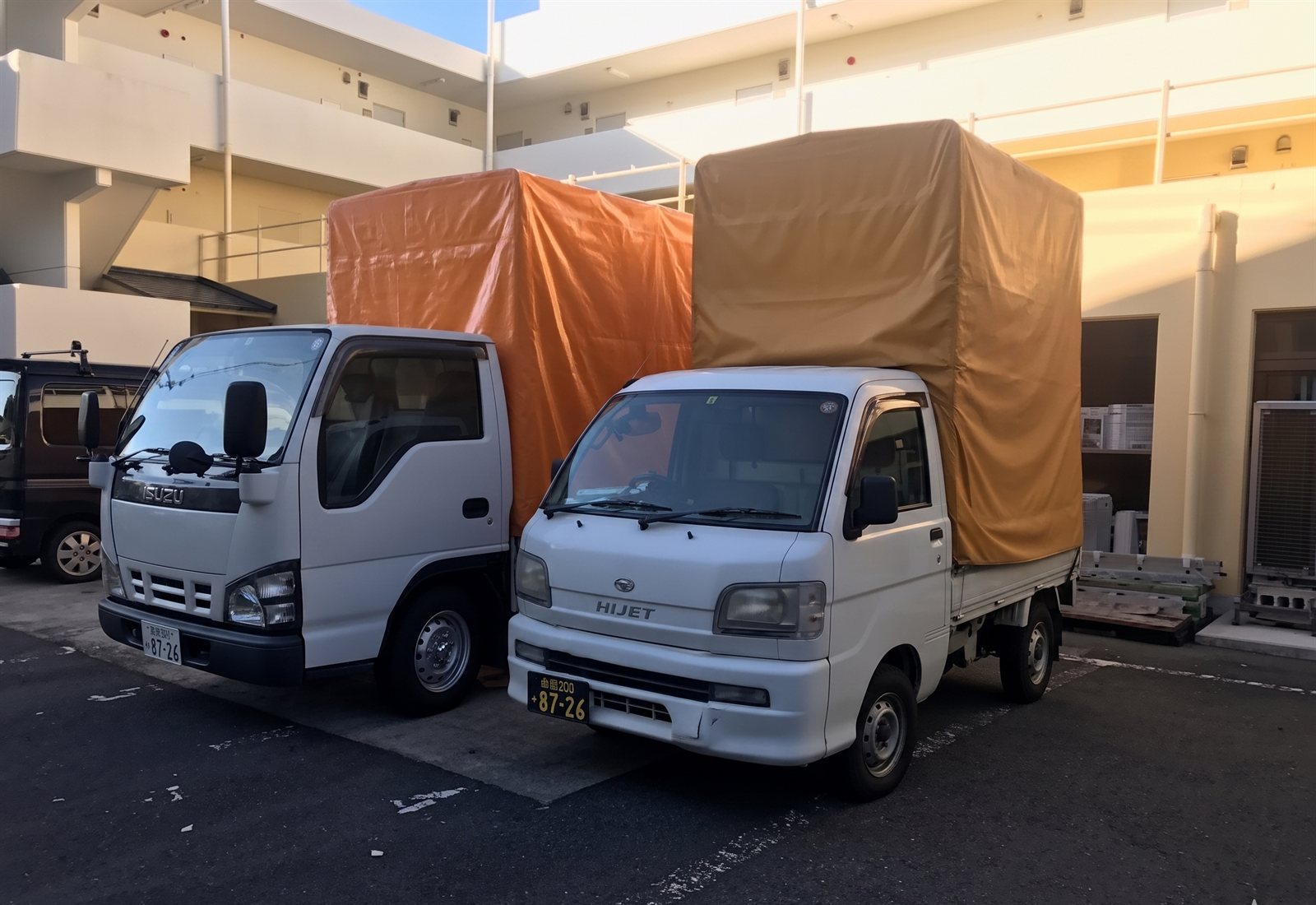 HAKKO幌付きトラック2台並び（左：1.5tトラック／右：軽トラック）／屋根の約2倍まで積載可能