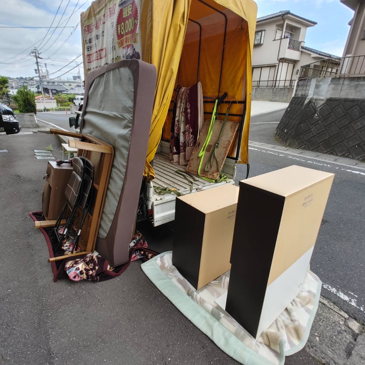 軽トラックへ積み込み中の家具とマットレス