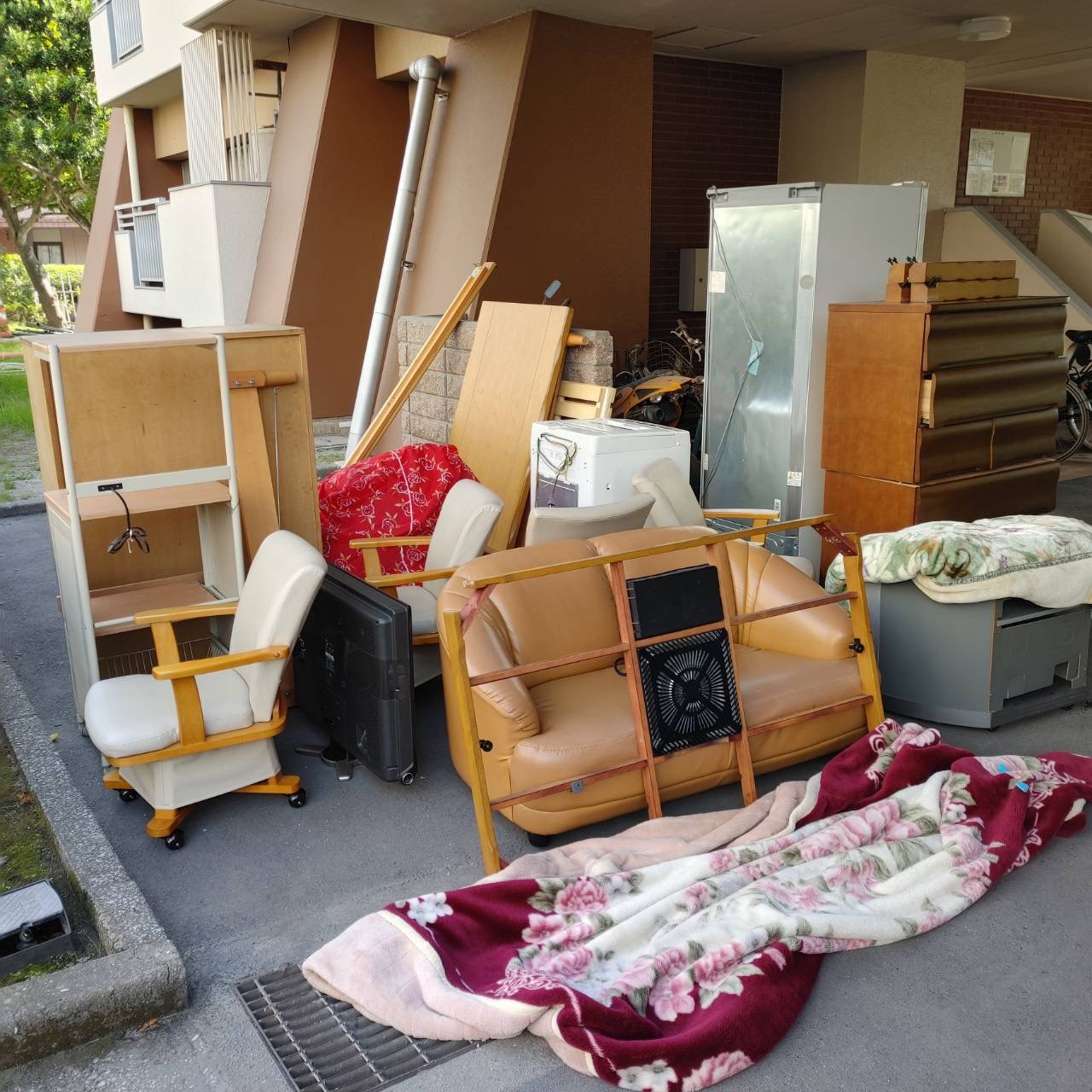 作業前(ソファ、回転いす、冷蔵庫、洗濯機、チェスト、毛布などが並んでいる)