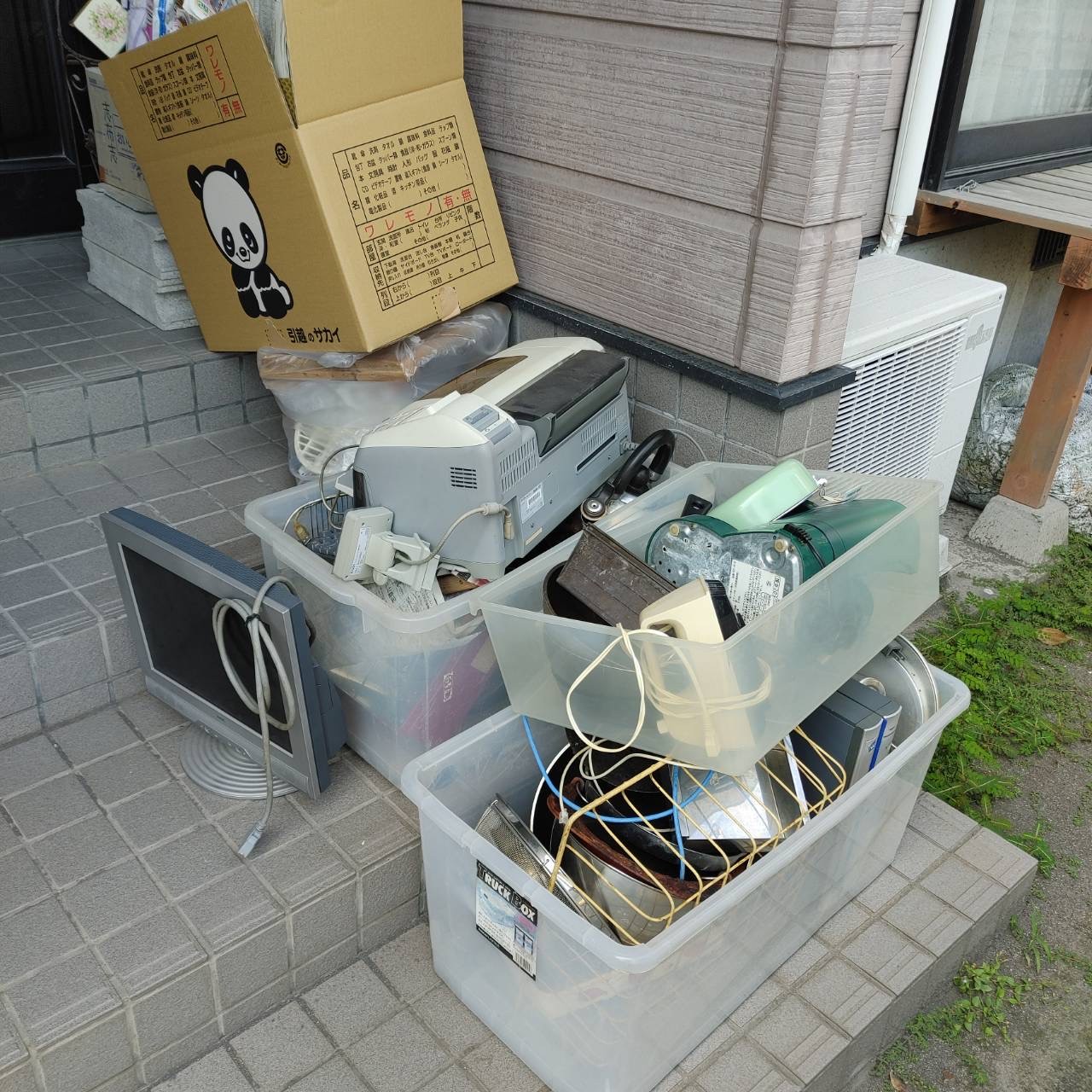 作業前の玄関まわり(プリンターや鍋を入れた収納ケース、モニター、段ボールが置かれた状態)